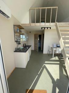 a kitchen with a sink and a loft at Laukbaloži Holiday houses in Jūrkalne