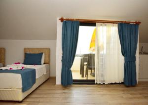 um quarto com uma cama e uma janela com cortinas azuis em Demyra Boutique Hotel em Demre