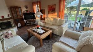 a living room with couches and a coffee table at Ferienhaus Vogtlandresidenz in Auerbach