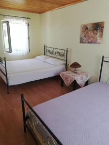1 dormitorio con 2 camas y ventana en North Evia Evanthia Greece, en Kourkouloí