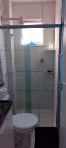 baño con aseo y puerta de ducha de cristal en Cantinho dos Rehm, en Fortaleza