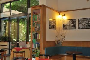 una habitación con una mesa y una estantería con libros en Hotel Galleano en Marina dʼAndora