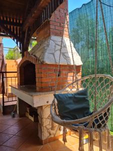 a patio with a brick oven with a swing at Dream House Rajic in Trpanj