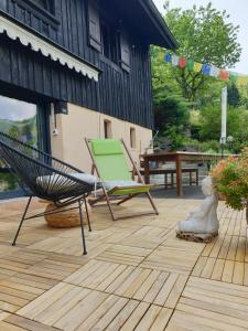 een patio met een hangmat, een stoel en een tafel bij Agréable chambre d'hôtes, au calme, dans la nature in Roches