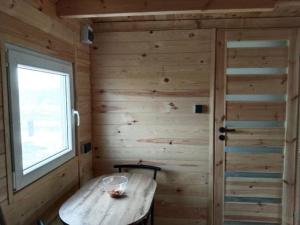 a small room with a wooden wall with a wooden table at domek letniskowy Agroturystyka Sajkiewicz in Chmielnik +2 photos