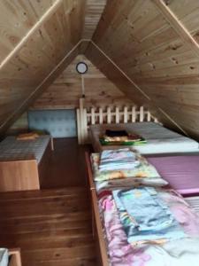 a room with two bunk beds in a wooden attic at domek letniskowy Agroturystyka Sajkiewicz in Chmielnik