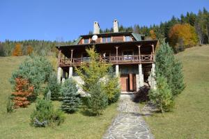 a large wooden house on a hill with trees at Kazkova Sadyba in Slavske