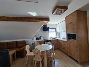 Una cocina y una sala de estar con mesa y sillas. en Domek u Jarząbków, en Ciche