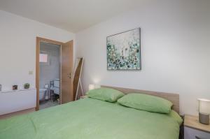 a bedroom with a bed with green pillows at Apartment Stella di Mare in Krk