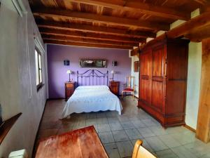 - une chambre avec un lit blanc et une armoire en bois dans l'établissement Neithea, à Bóveda