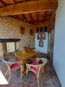 a dining room with a wooden table and chairs at Neithea in Bóveda