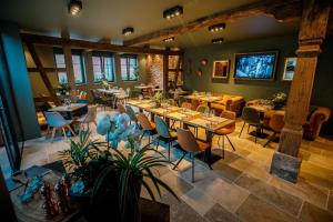 a restaurant with tables and chairs in a room at Le Vingt-Deux in Mietesheim