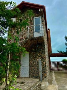 a stone building with a door and a balcony at Cottages at Villa Del Mar Kvariati in Kvariat'i