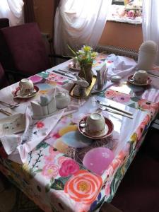 a table with a table cloth with cups and plates on it at Hotel Eulenhof in Gransdorf