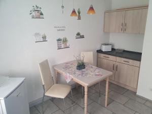a kitchen with a table and chairs with plants on the wall at Ferienhaus Margarete in Dankerode