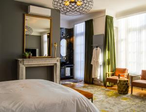 a bedroom with a bed and a fireplace and a mirror at The Old Beech in Antwerp