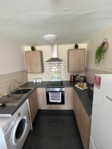 a small kitchen with a stove and a dishwasher at Elite 47 Stays in Newcastle upon Tyne