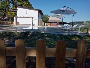 a wooden fence in front of a building with an umbrella at Cascina Pelizza in Casale Monferrato