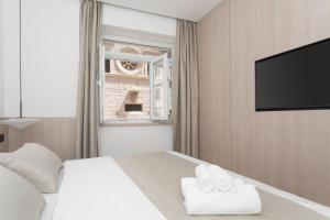 a bedroom with a bed and a flat screen tv at Étoile apartment in Šibenik