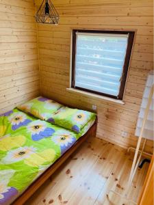 a bed in a room with a window at Domki u strażaka in Jastarnia