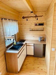 kuchnia w drewnianej kabinie z umywalką w obiekcie Domki u strażaka w Jastarni