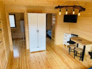 a dining room with a table and a white door at Domki u strażaka in Jastarnia +6 photos
