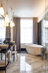 a bathroom with a large tub and two sinks at The Old Beech in Antwerp