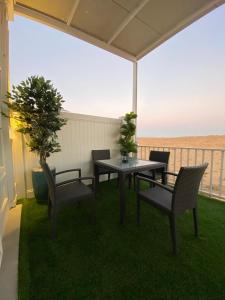 a table and chairs on a patio with a view of the ocean at Desert Inn Resort and Camp in Ras al Khaimah