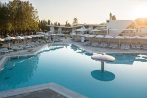 une grande piscine avec des chaises et un tabouret dans l'établissement Falkensteiner Premium Mobile Homes and Camping Zadar, à Zadar