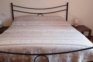 cama con marco negro y colcha blanca en Beautiful 2-Bed House in Longoio Bagni Di Lucca en Longoio