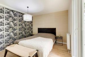een slaapkamer met een bed en een muur met veren bij Appartement de Standing Aux Portes de Paris in Nogent-sur-Marne