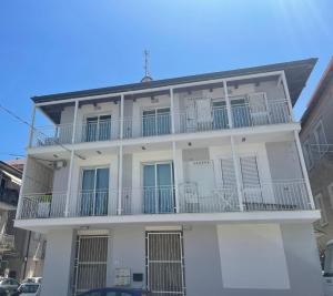 a white house with balconies on a street at Da Cate - Appartamento al mare in Grottammare