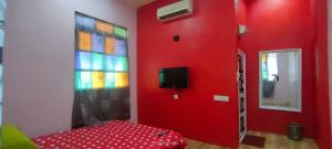 um quarto vermelho com uma parede vermelha em Bungalow Mat Hj Limah em Alor Setar
