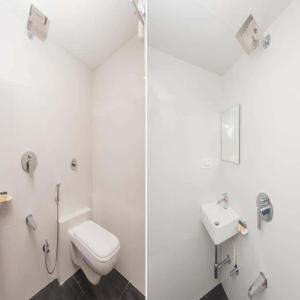 a white bathroom with a toilet and a sink at Hotel Heritage - Near Trade Center, Visa Consulate BKC in Mumbai