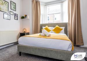 a bedroom with a bed with yellow pillows and a window at Luke Stays - Kitchener Street in Sheriff Hill