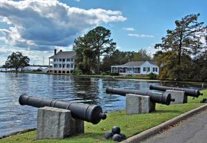 two cannons on the grass near a body of water at The Edenton Collection-The Granville Queen Inn in Edenton
