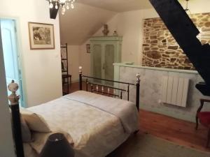 sypialnia z łóżkiem i kamienną ścianą w obiekcie The Old Cider Press w mieście Carnoët