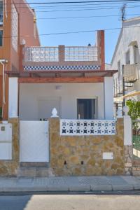 a house with a stone wall and a balcony at Casa Aigua Blanca Oliva in Oliva