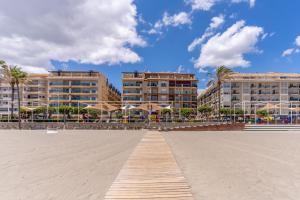 eine Promenade inmitten eines Strandes mit Gebäuden in der Unterkunft ESTEPONA BEACHSIDE in Estepona