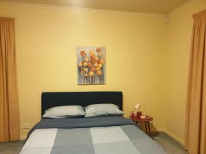 a bedroom with a bed and a painting of fruit at Vacation Getaway in Rowville