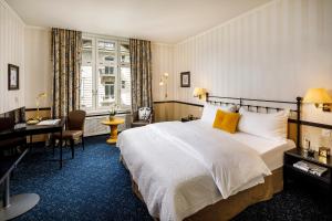 a hotel room with a bed and a desk at Opera Hotel Zürich in Zurich