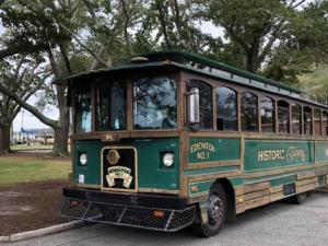an old green bus parked in a park at The Edenton Collection-Captain's Quarters Inn in Edenton