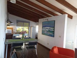 een keuken en een woonkamer met een tafel en stoelen bij Dos Violetas in Mocanal