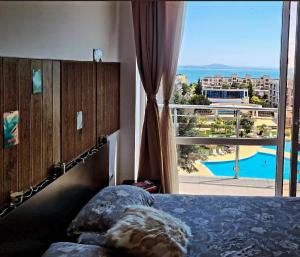 a bedroom with a bed and a view of a pool at Atlantis Resort Sea View in Burgas