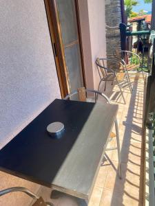 Hotel Alkionis في إيريسوس: طاولة سوداء مع كراسي على الفناء