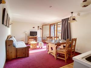 a living room with a table and chairs and a television at Appartement Les Menuires, 2 pièces, 4 personnes - FR-1-344-145 in Les Menuires