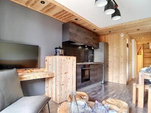 a kitchen with wooden walls and a couch in a room at Appartement Les Menuires, 4 pièces, 10 personnes - FR-1-344-366 in Les Menuires