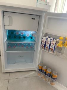 un frigorifero aperto pieno di bevande e condimenti di LAGUNA BLU Camera TRAMONTO con terrazza panoramica in comune a Chioggia