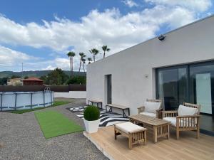 een patio met stoelen en tafels in een wit gebouw bij Casa Rural Espadan Suites in Artana