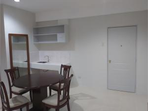 a table and chairs in a kitchen with a sink at OYO 881 Nest Suites in Manila